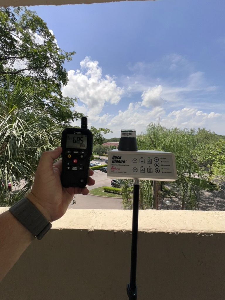 Outdoor baseline air sample being collected from an upper-floor balcony of the five-story Coconut Creek condominium building, with multiple building levels visible below