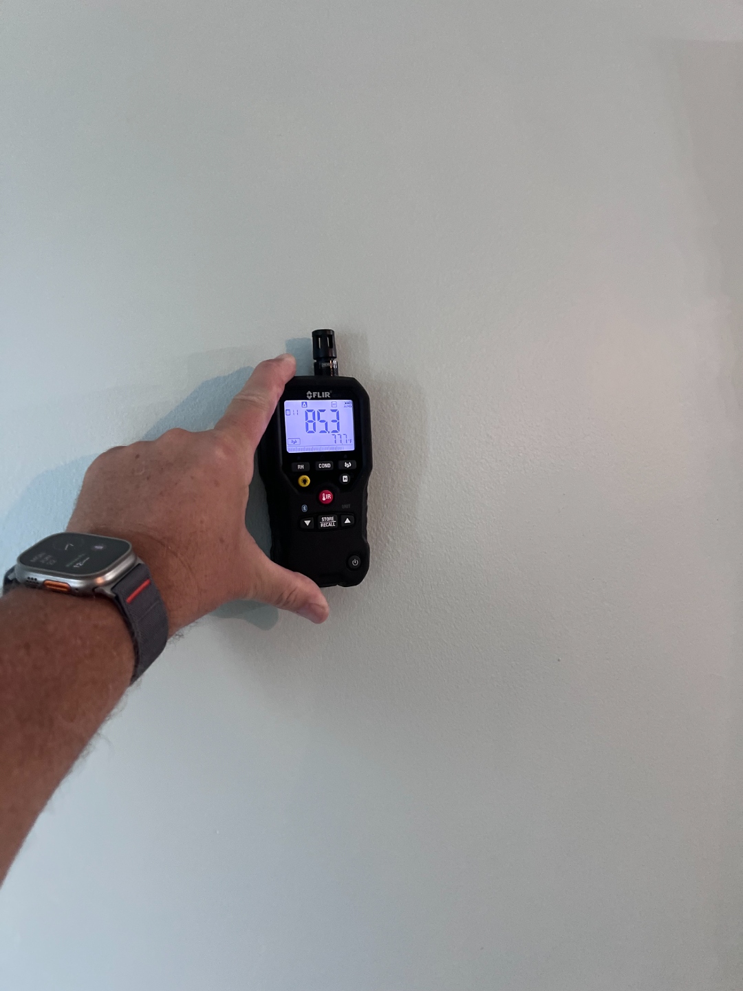 Inspector taking a moisture reading on a wall during an independent mold inspection
