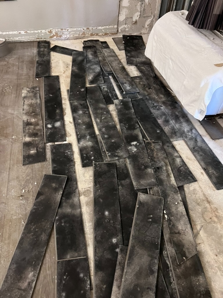 Rows of mold-contaminated wood flooring planks removed from a hotel room and laid out for disposal
